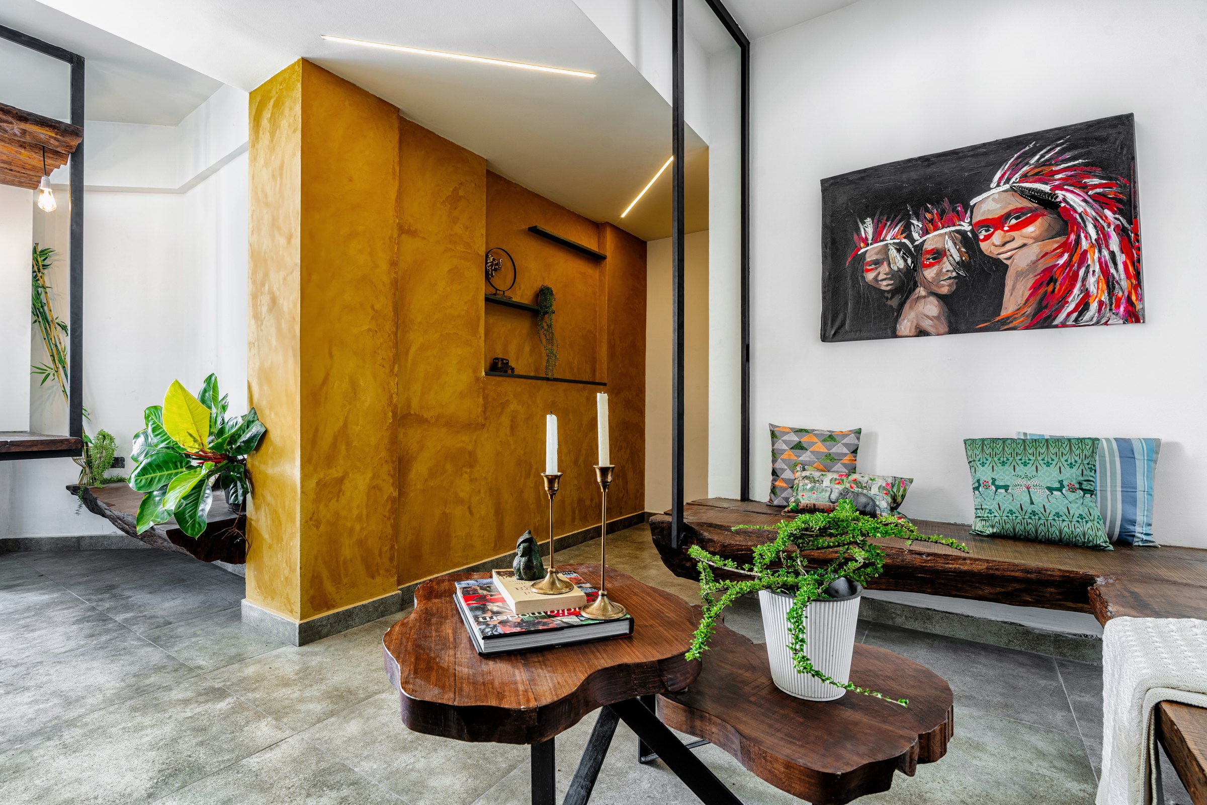 Ashcroft living space with raw flooring, a mustard partition, and curated artwork