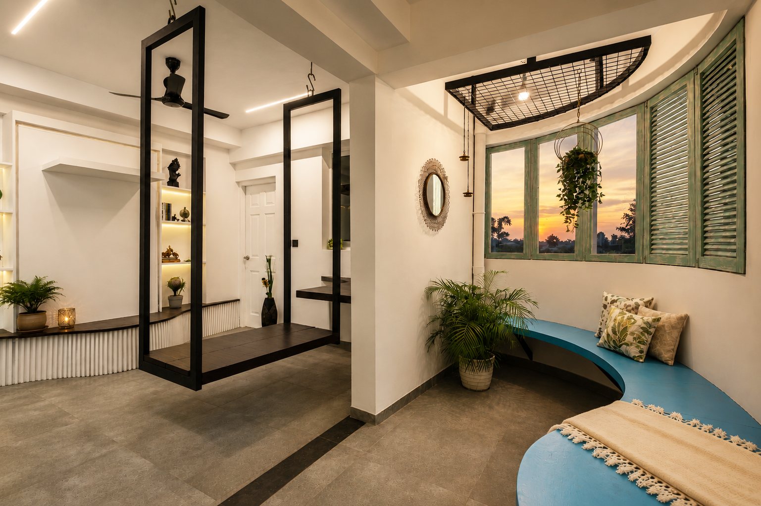 Wide bay-window seating area with black hanging frames and a blue bench at sunset