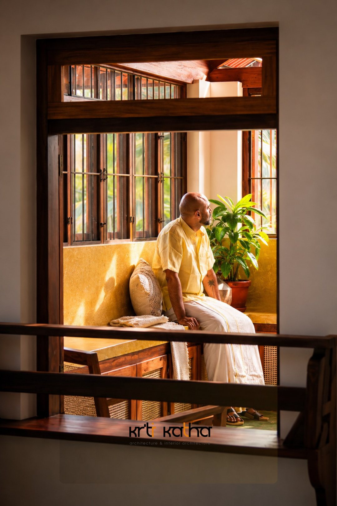 Older man seated in a sunlit ochre window alcove framed by dark wood