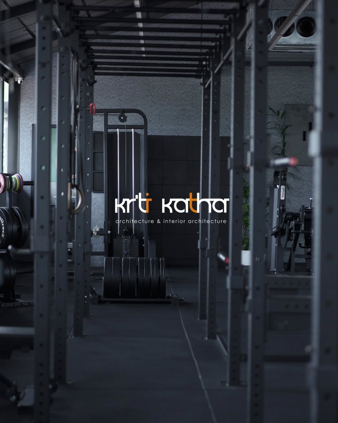 Long aisle through black strength racks with weight plates stacked at the far end
