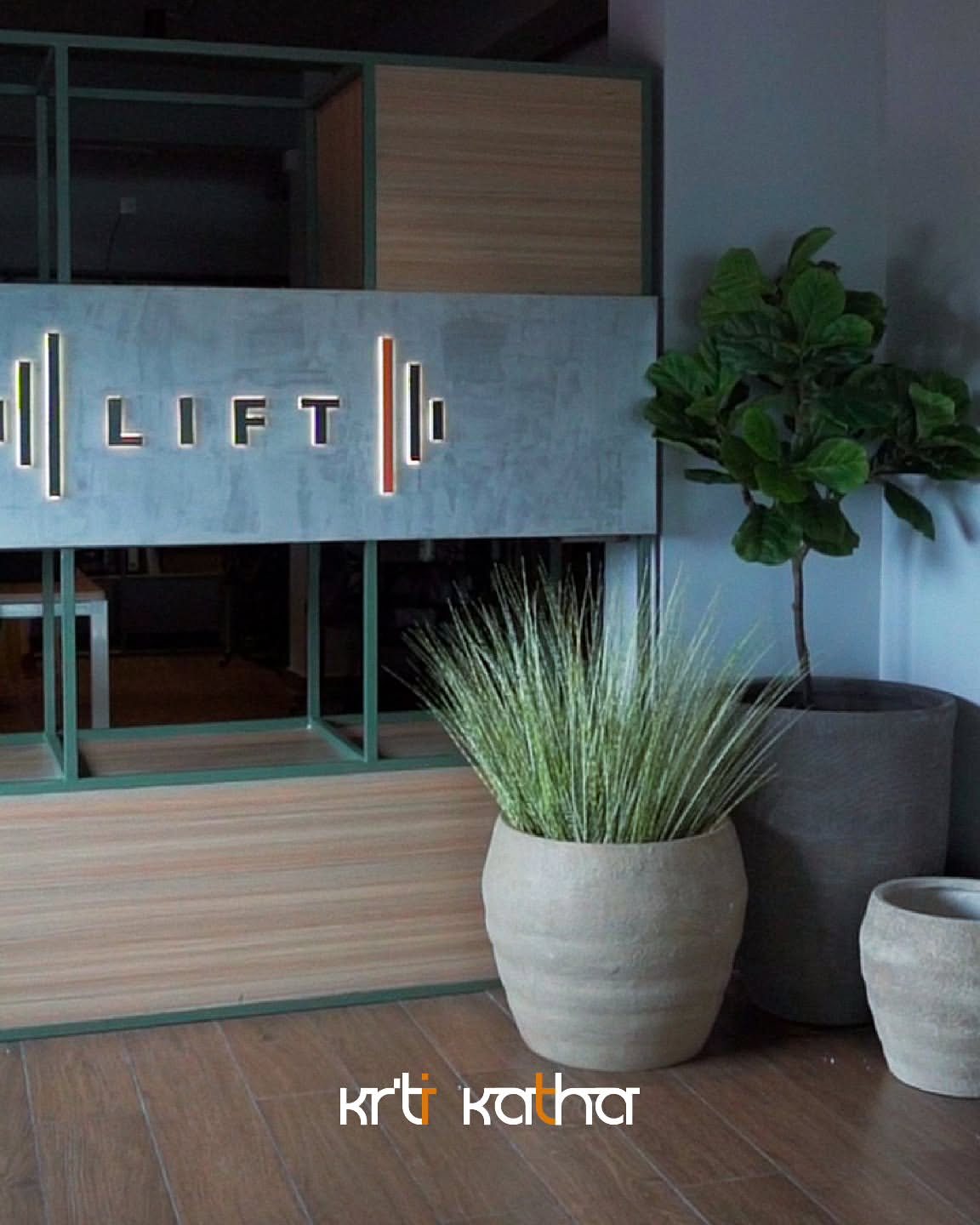 Reception counter with illuminated LIFT lettering, wood paneling and large planters